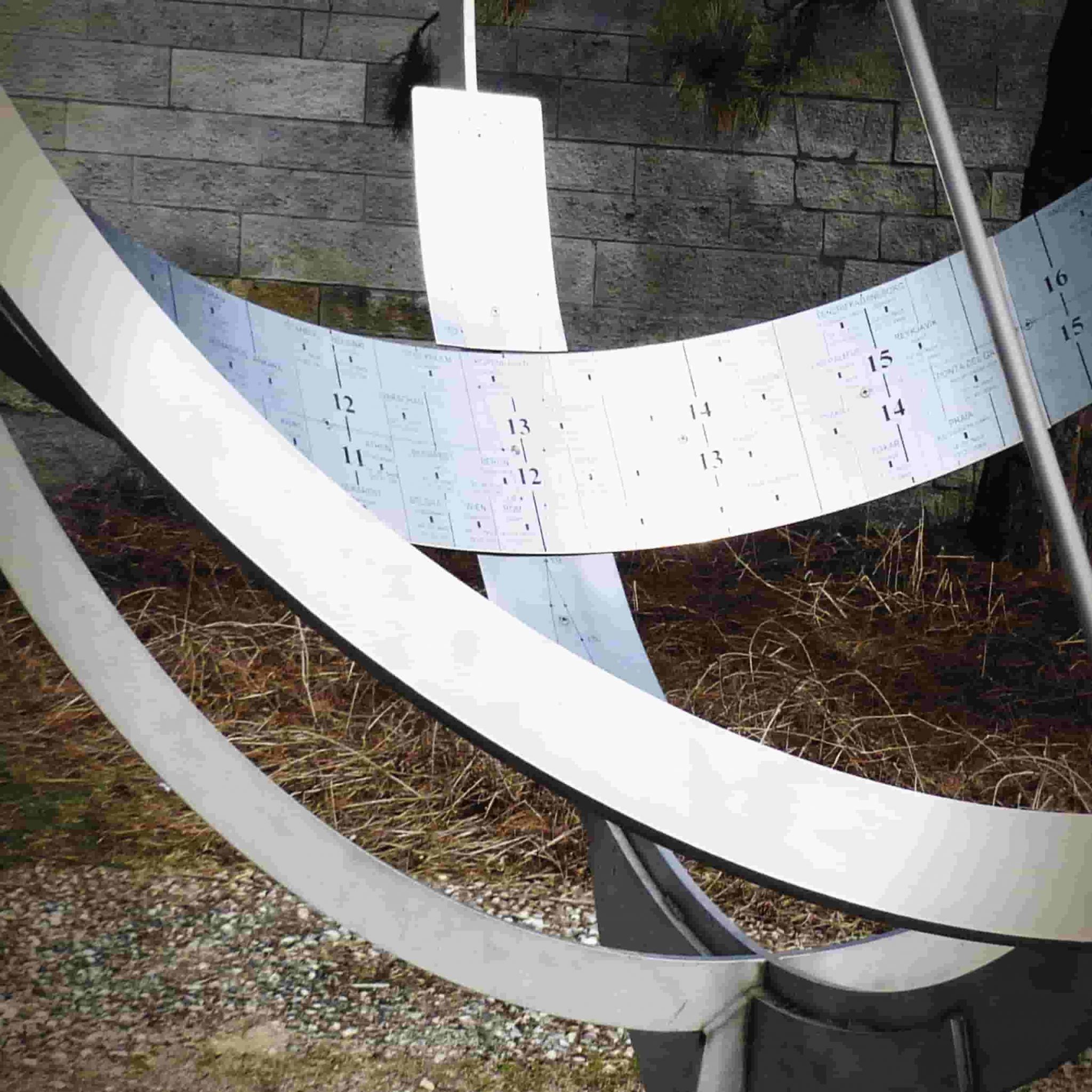 Sonnenuhr mit sich kreuzenden Metallringen und Stundenskala im Außenbereich – Profilbild der Kita miedelHaus.