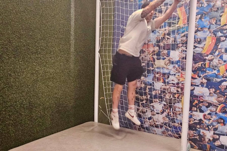Mitarbeiter springt im Fußballtor und fängt einen Ball.
