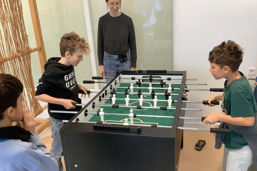 nder spielen begeistert Tischkicker mit ihrer Betreuerin.