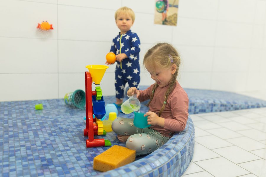 Kinder experimentieren mit Wasser und Spielmaterial im Nassraum einer Kindertagesstätte der bürgerhilfe ingolstadt KiTa GmbH