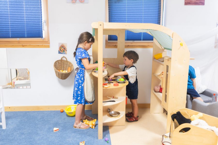 Zwei Kinder spielen gemeinsam in einer Spielküche im Gruppenraum einer Kindertagesstätte der bürgerhilfe ingolstadt KiTa GmbH