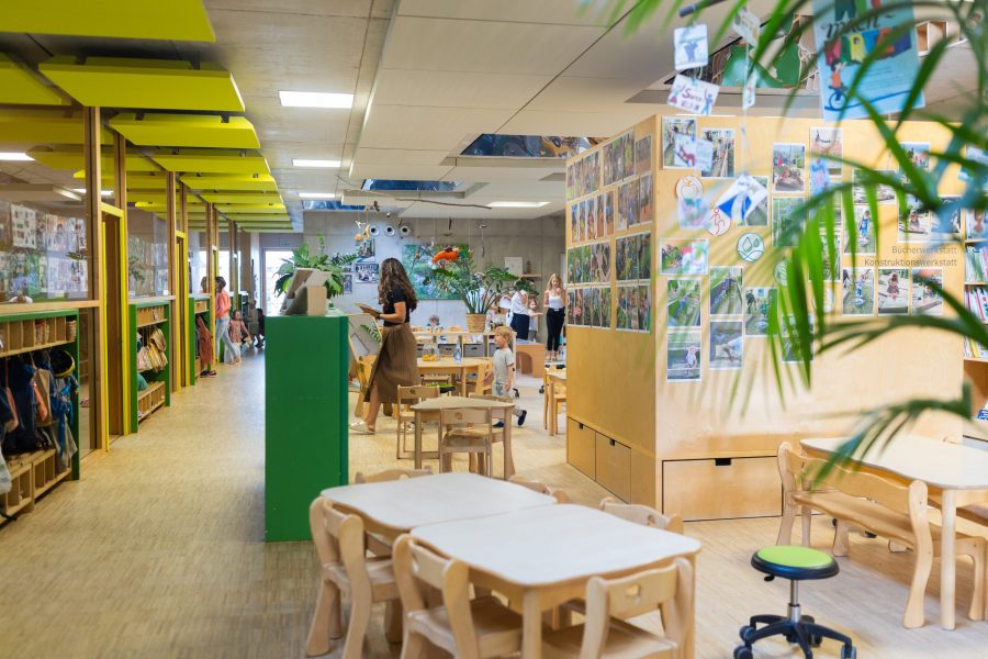 Heller Gruppenraum in einer Kindertagesstätte der bürgerhilfe ingolstadt KiTa GmbH mit Kindern, Erzieherinnen und vielfältigen Spiel- und Lernbereichen
