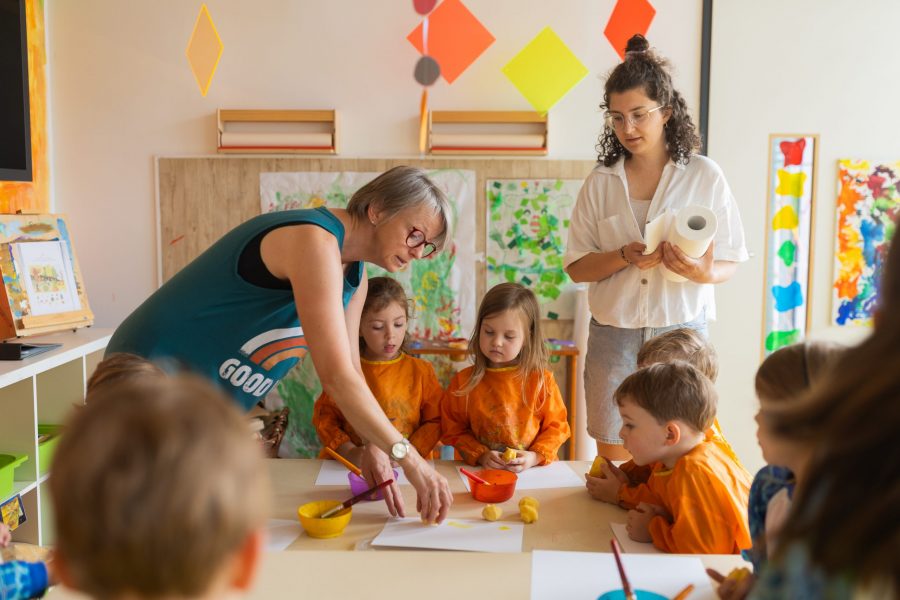 Pädagogische Fachkräfte begleiten Kinder beim kreativen Gestalten am Tisch in einer Kindertagesstätte in Ingolstadt.