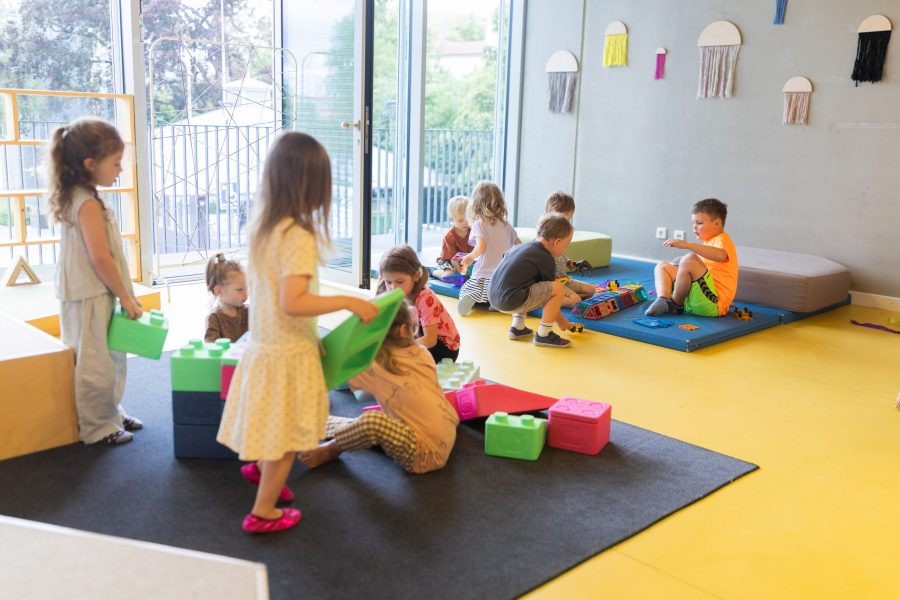 Kinder spielen und bauen gemeinsam mit Bausteinen im Innenraum einer Kindertagesstätte in Ingolstadt.