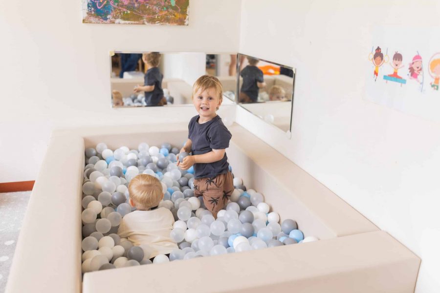 Zwei Kleinkinder spielen im Bällebad der Kita.