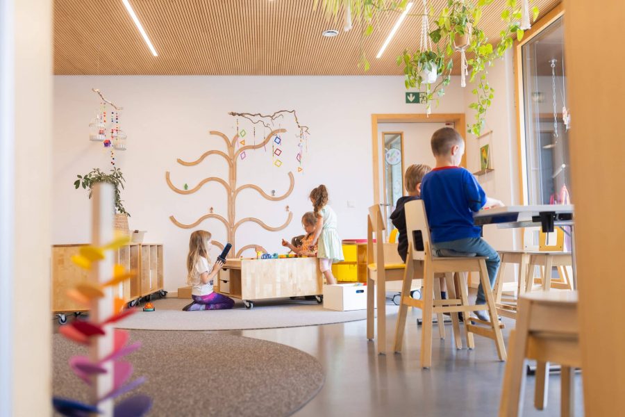 Kinder spielen im hellen Gruppenraum.