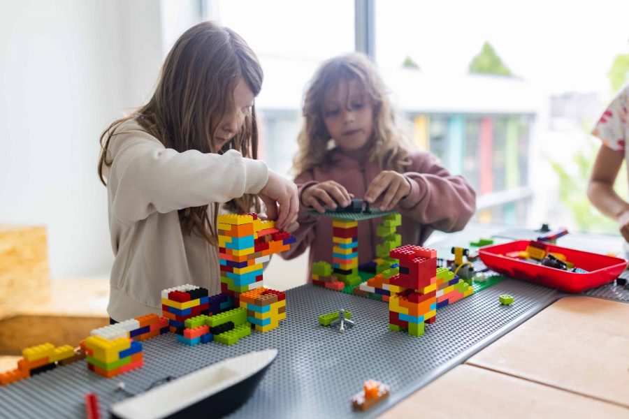 Zwei Kinder bauen mit bunten Bausteinen.
